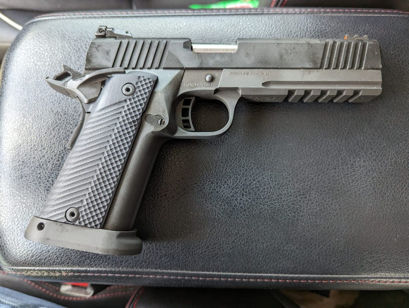 The same black double-stack 1911 photographed from the opposite side on its case