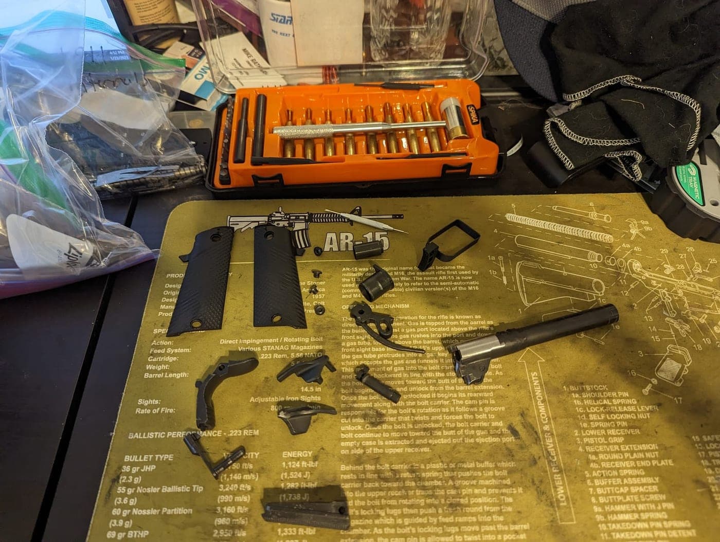 The pistol fully stripped to individual small parts, grips, springs and pins across the bench mat